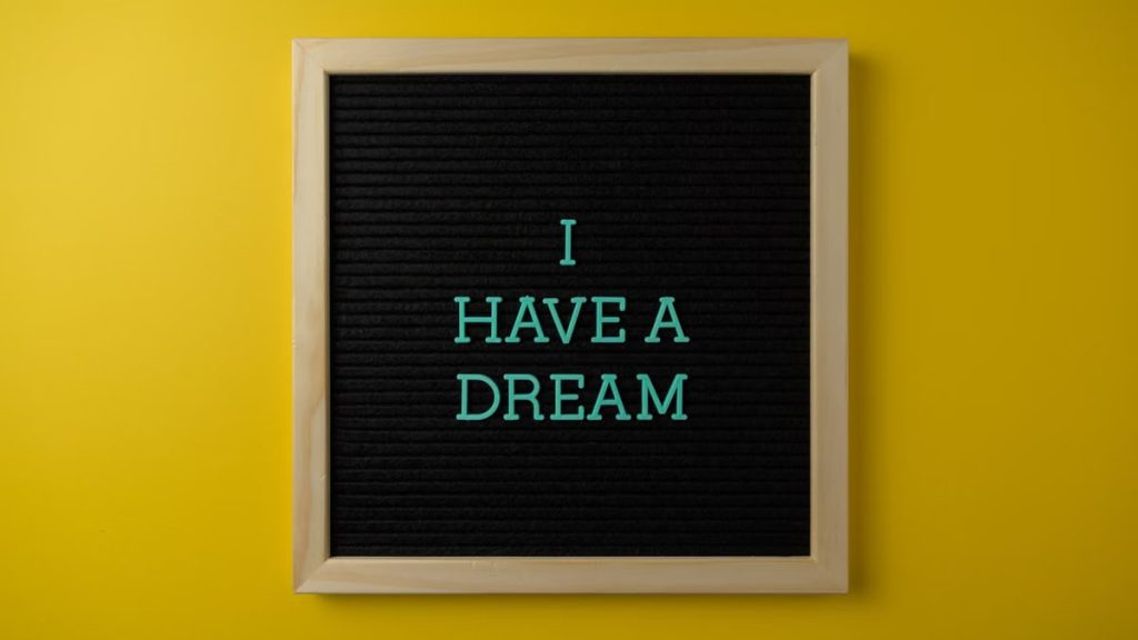 Close-up view of a letter board with 'I Have a Dream' message on a vibrant yellow background.